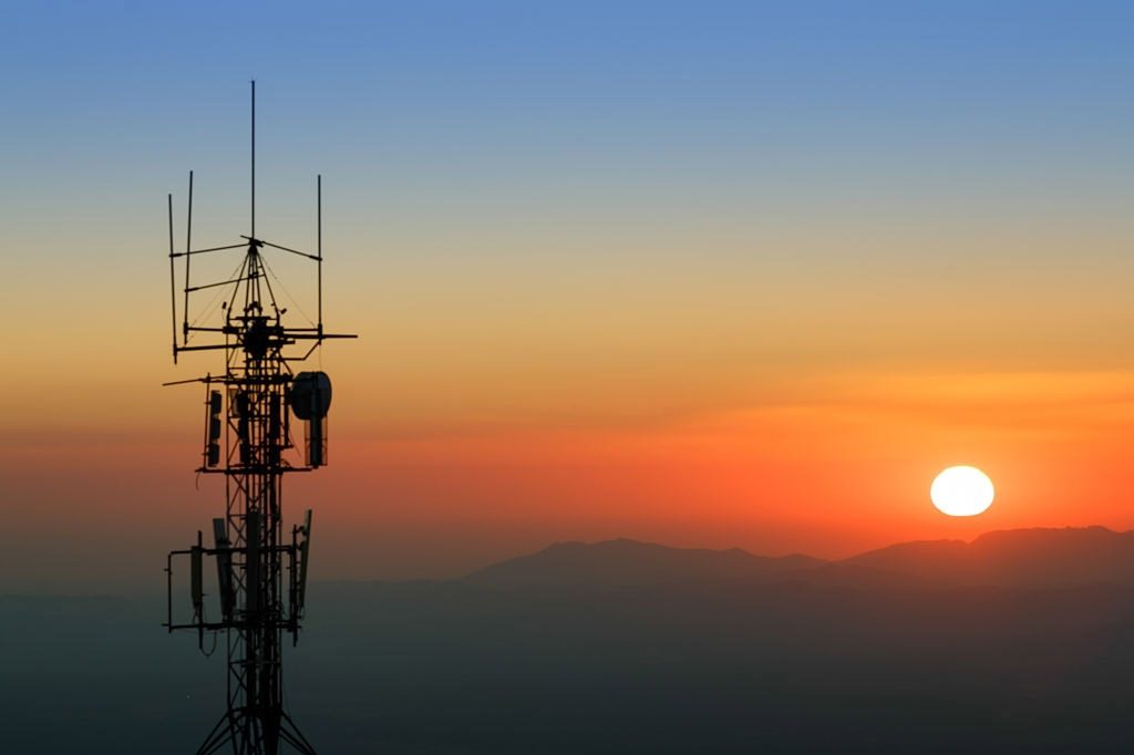 Communication tower backlit at sunset. With mountain range in the background. In the Sierra Nevada National Park, province of Granada, Spain.